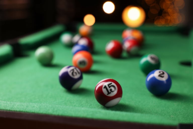 Many colorful billiard balls on green table, closeup
